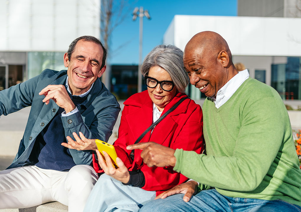 Group of eldery friends viewing their mobile phone.