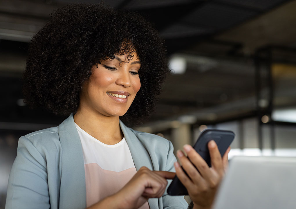 A young woman looking at her expenses through her mobile banking app on her phone.