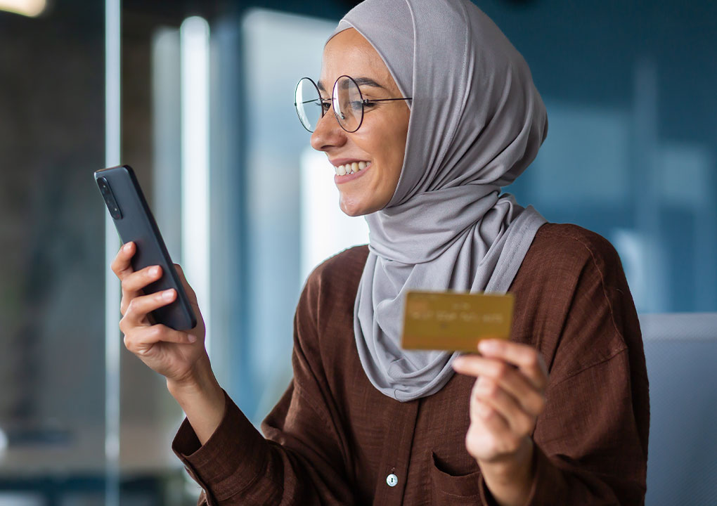 A young person paying a bill through the banks online bill pay feature on their phone.