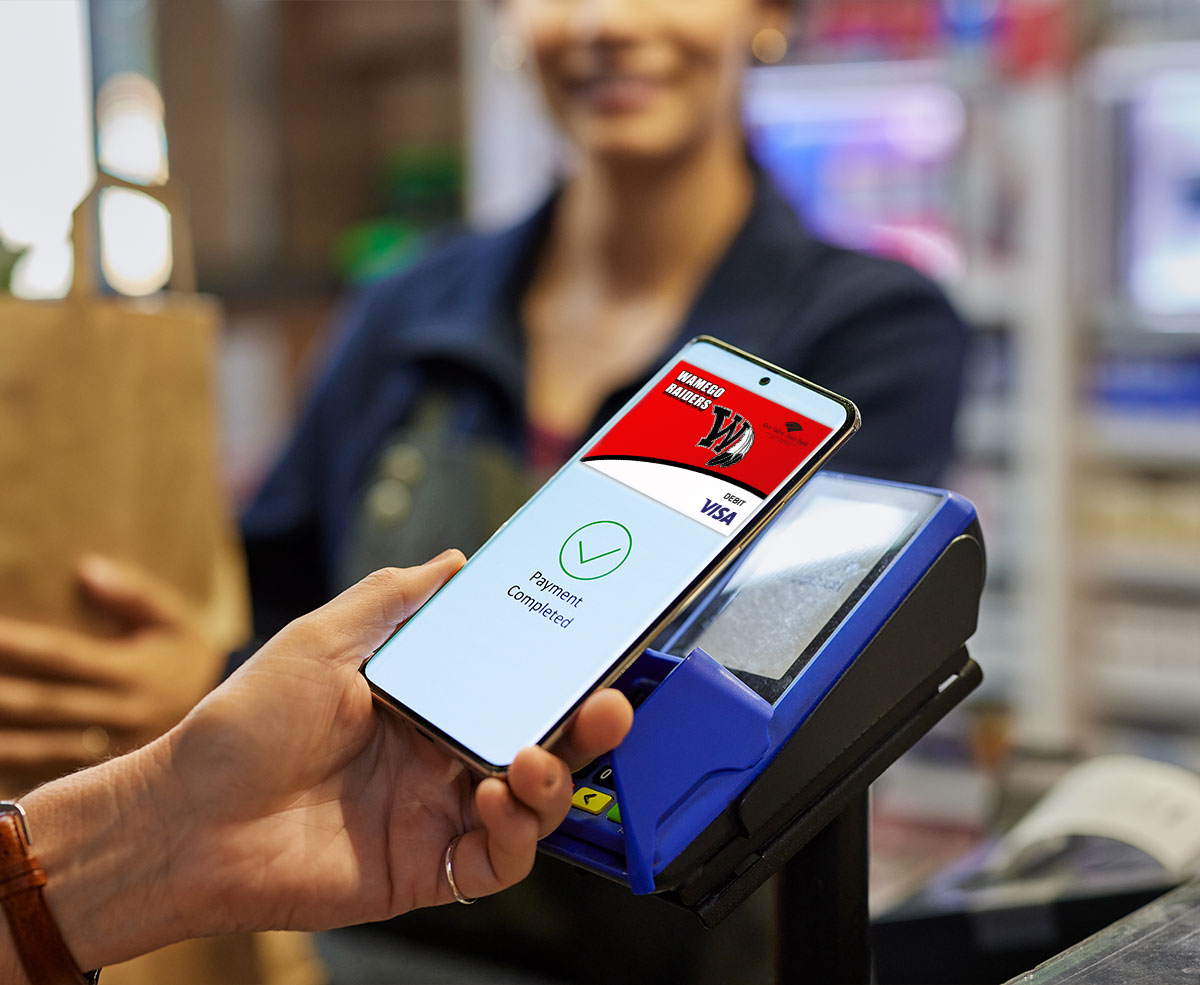A KSVB customer using their KSVB banking card in their digital wallet to pay at the store.