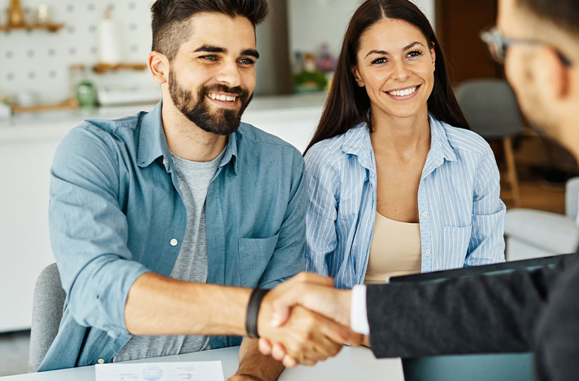 A young couple talking to a banking manager to open an account.